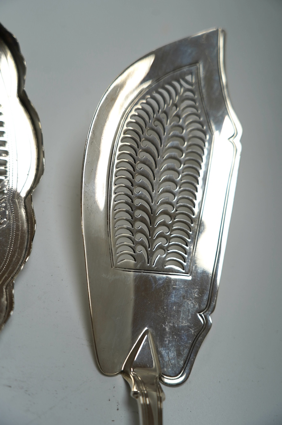 A George III silver fish slice with part gallery border, Henry Chawner, London, 1791, 30.4cm and a later George IV silver King's pattern fish slice, London, 1821. Condition - poor to fair